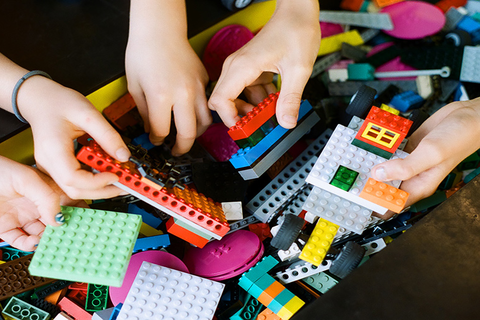 Close up image of hands holding legos 