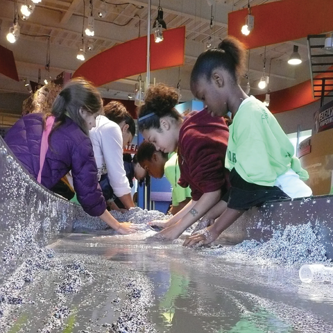 Kids playing at the stream table