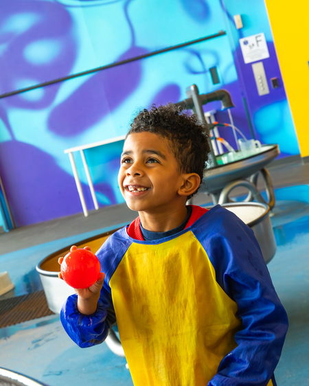 Young boy playing with the water ball at exhibit